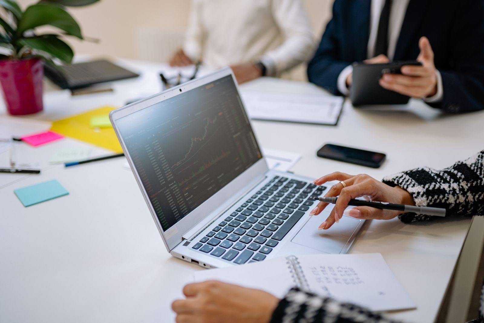 Business professionals discussing a digital project around a laptop